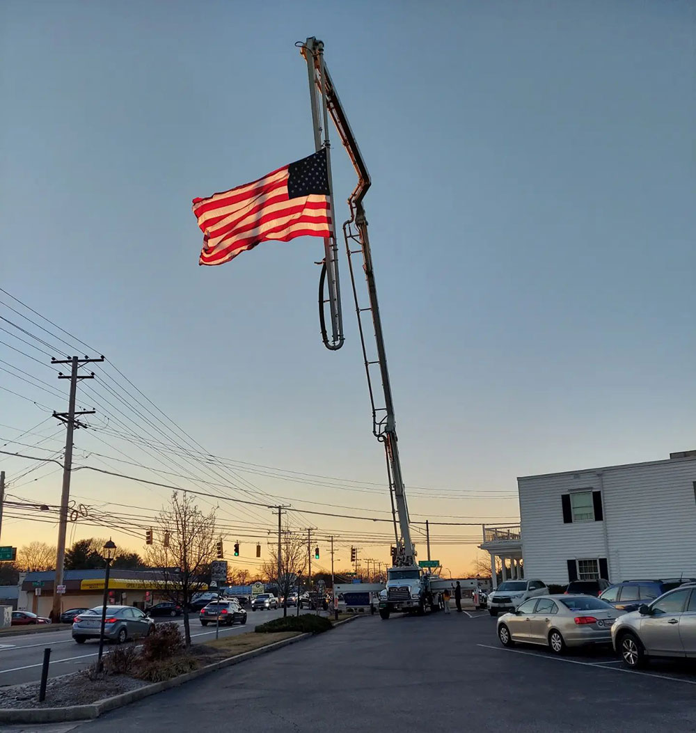 boom pump raised with an american flag waving in the wind