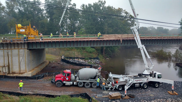boom pump pouring concrete on a bridge from below
